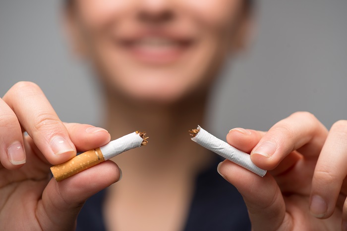 A person snapping a cigarette in two