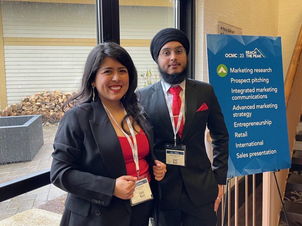 Andrea Tapia and Manasdeep Singh, wearing business suits and smiling