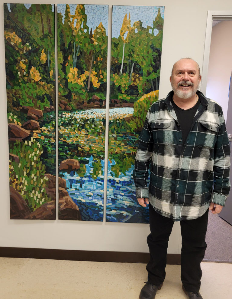 Student Herbert Pryke with his  painting "Just around the Bend" at the Owen Sound Campus.
Student Herbert Pryke with his painting ��“Just around the Bend”.