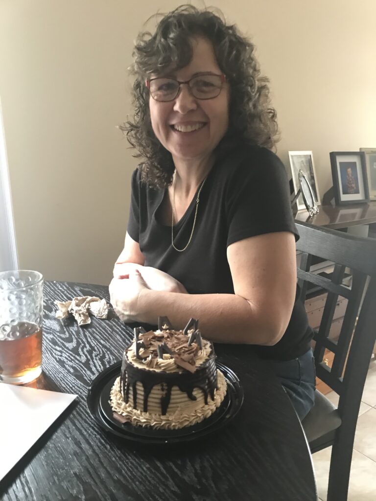 Christine Chapman, first year paralegal student sitting at a table with a cake.