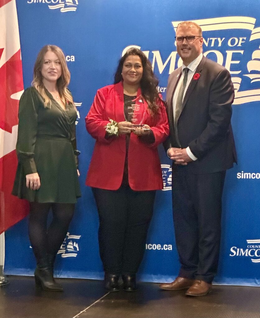 Three people pose at the Simcoe County Newcomer Recognition Awards.