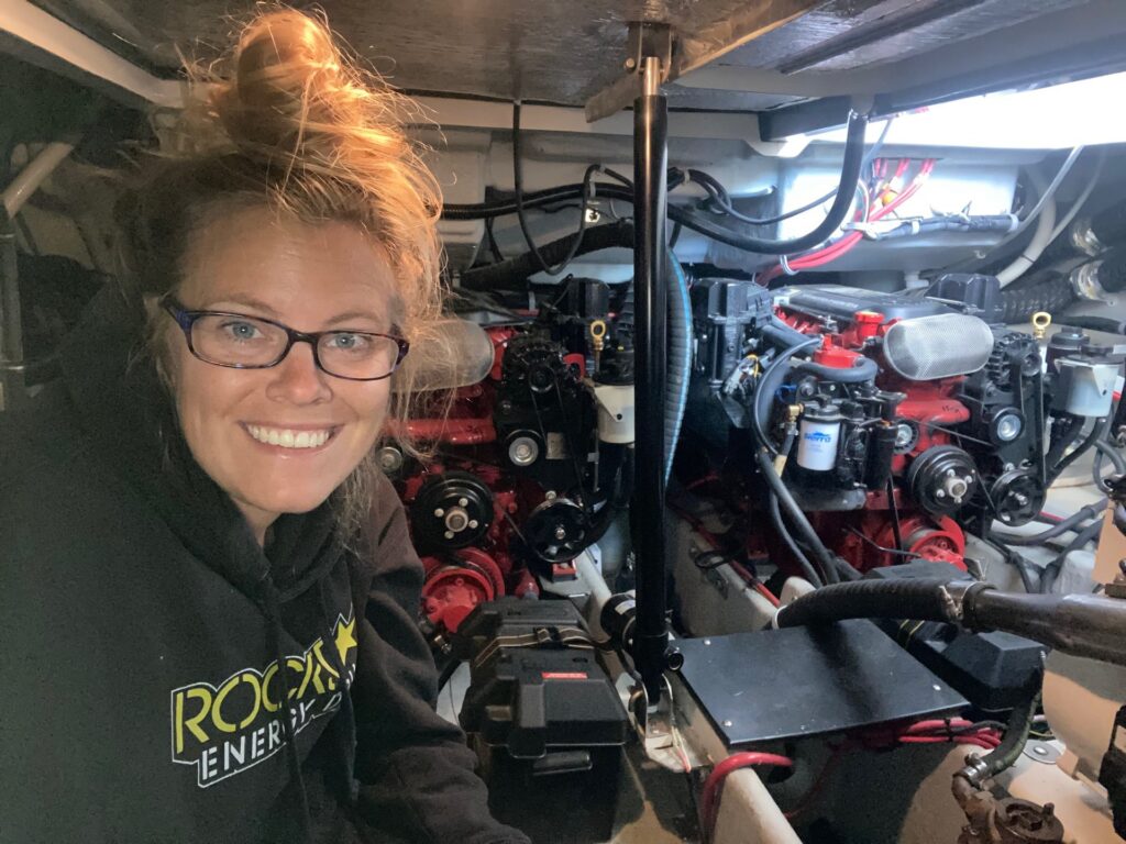 Woman with glasses sitting in front of boating equipment.