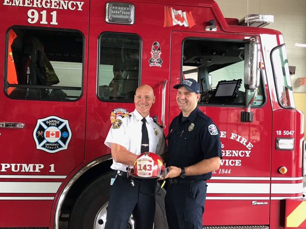 Two people standing in front of City of Barrie fire truck.
