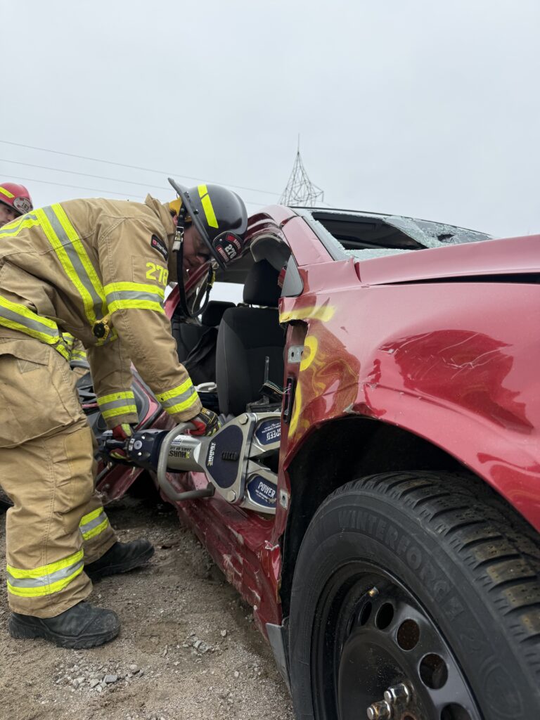 Firefighter student using extraction tool.