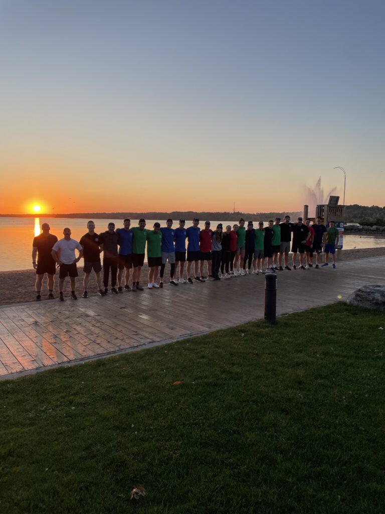 group of fire students standing in front of the water.