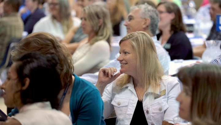 Attendees of a conference smiling and looking engaged