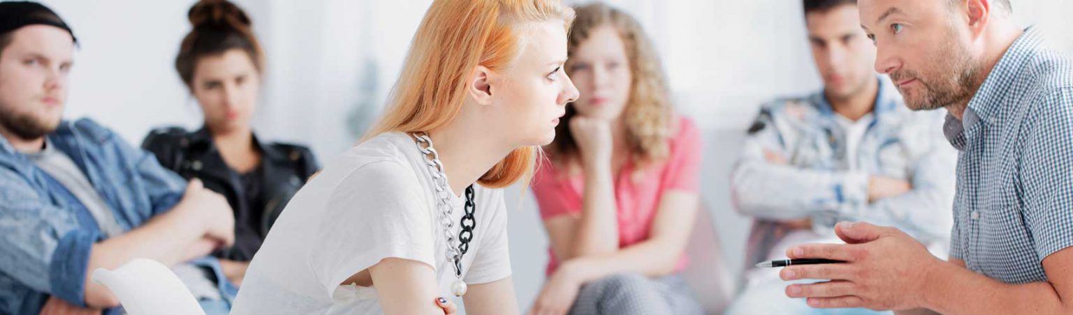A counsellor provides guidance to a member in recovery at an addictions support group