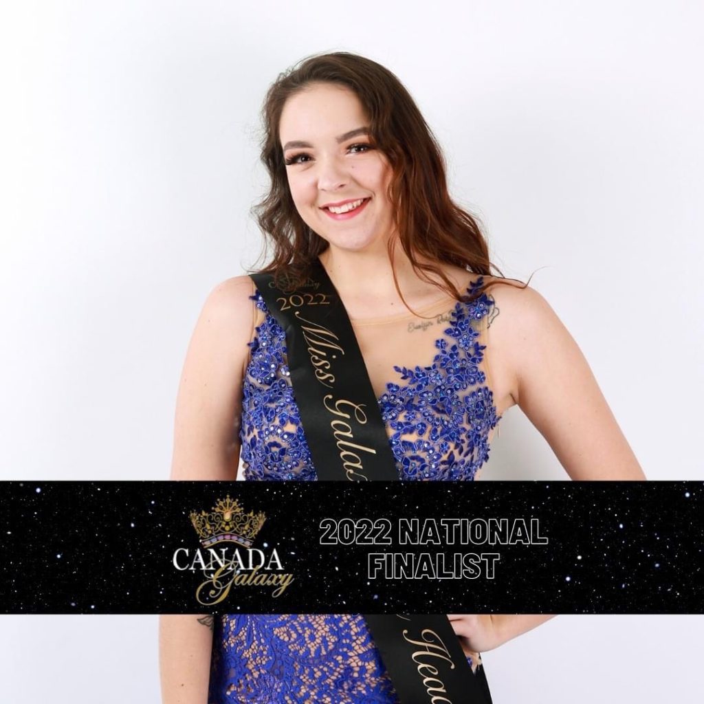 A person in a purple dress, wearing a sash reading Miss Galaxy Lions Head, smiles at the camera. Text: 2022 National Finalist 
