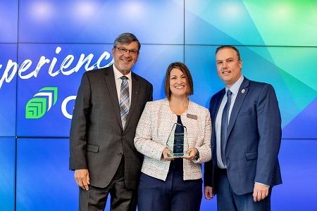 Georgian alumna Kelly Watson (class of 2012, centre) accepts a Distinguished Alumni Award from Richard C. Gauthier (left), Chair of the Georgian College Board of Governors, and Kevin Weaver (right), President and CEO, Georgian College.