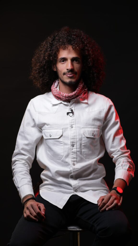 A Georgian College student sits for a photo with a black background.