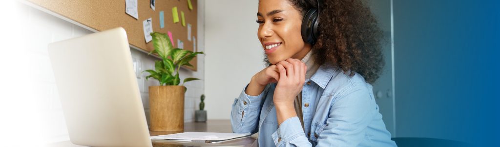 woman on computer with headphones