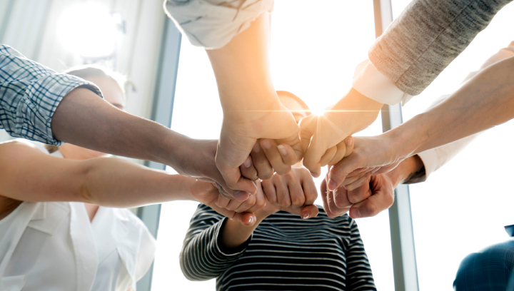 Group of people fist bumping