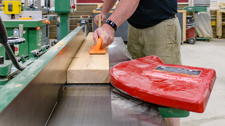 Close-up-of-a-male-carpentry-student-working-on-a-project-in-the-shop-space