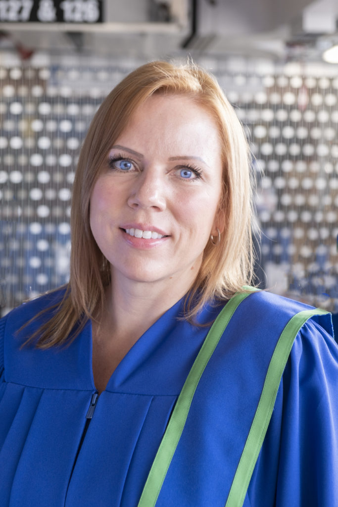 A person wearing a blue graduation gown.