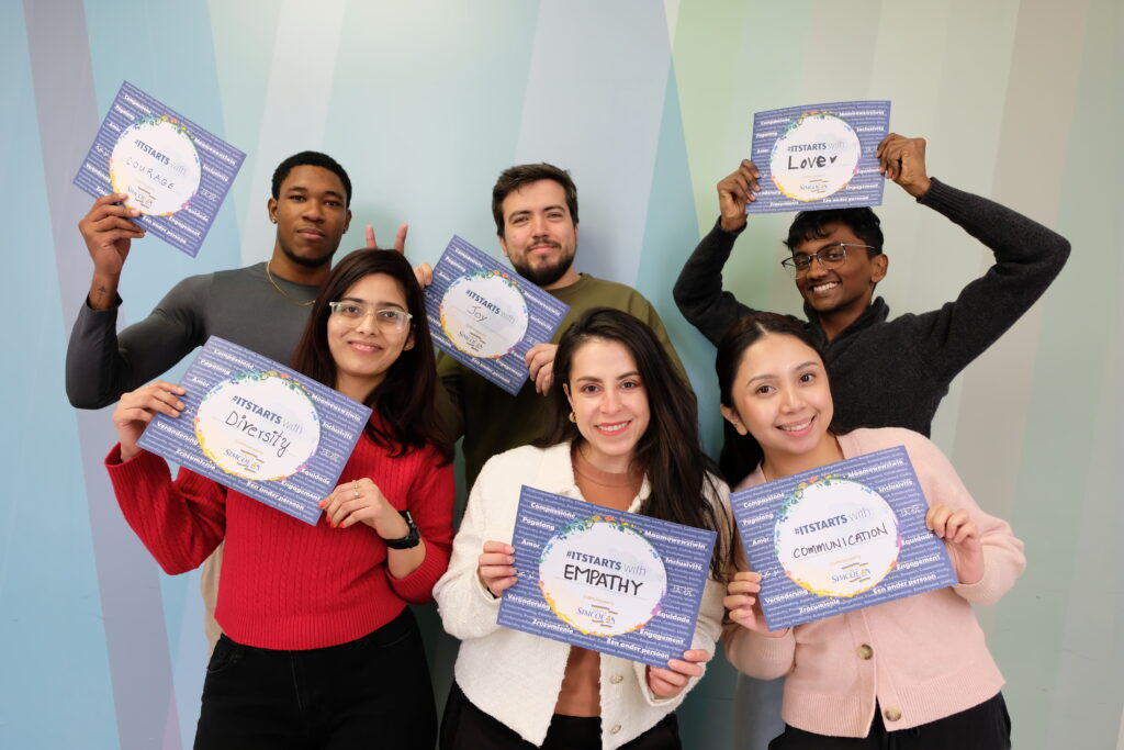 Group of six people holding up signs that fostering acceptance, equity and diversity while combating racism and discrimination.