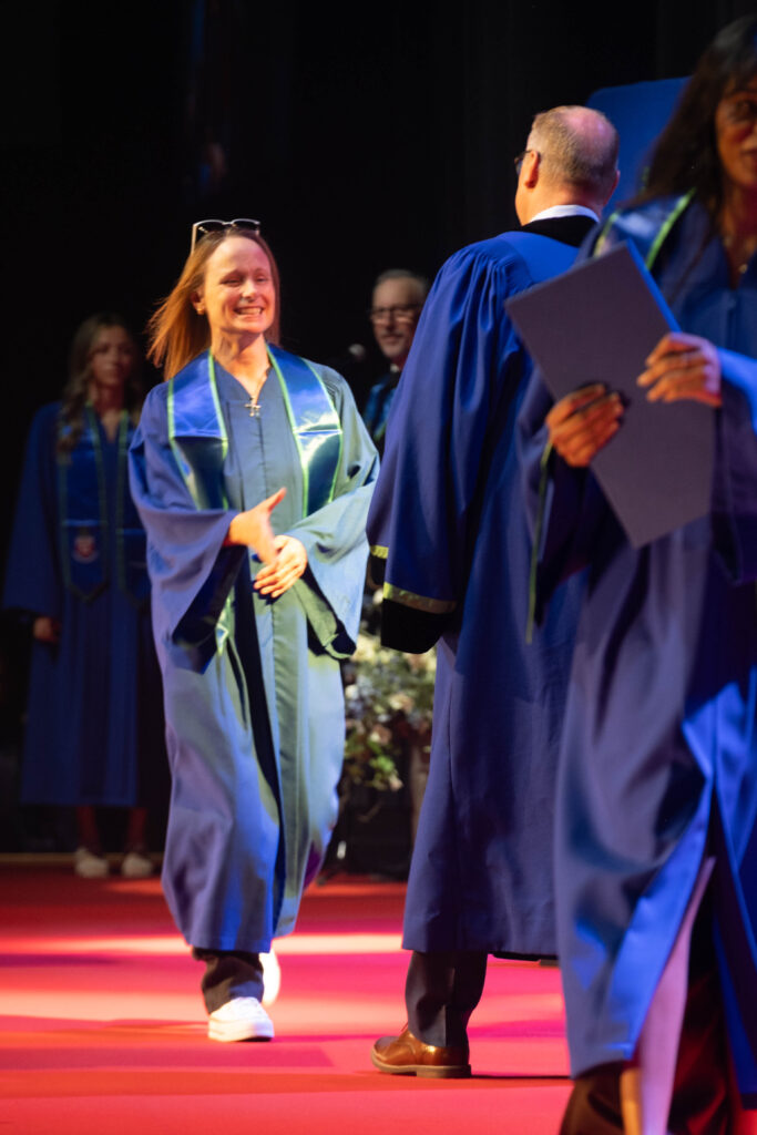 Nancy Dewar crossing the stage at convocation.