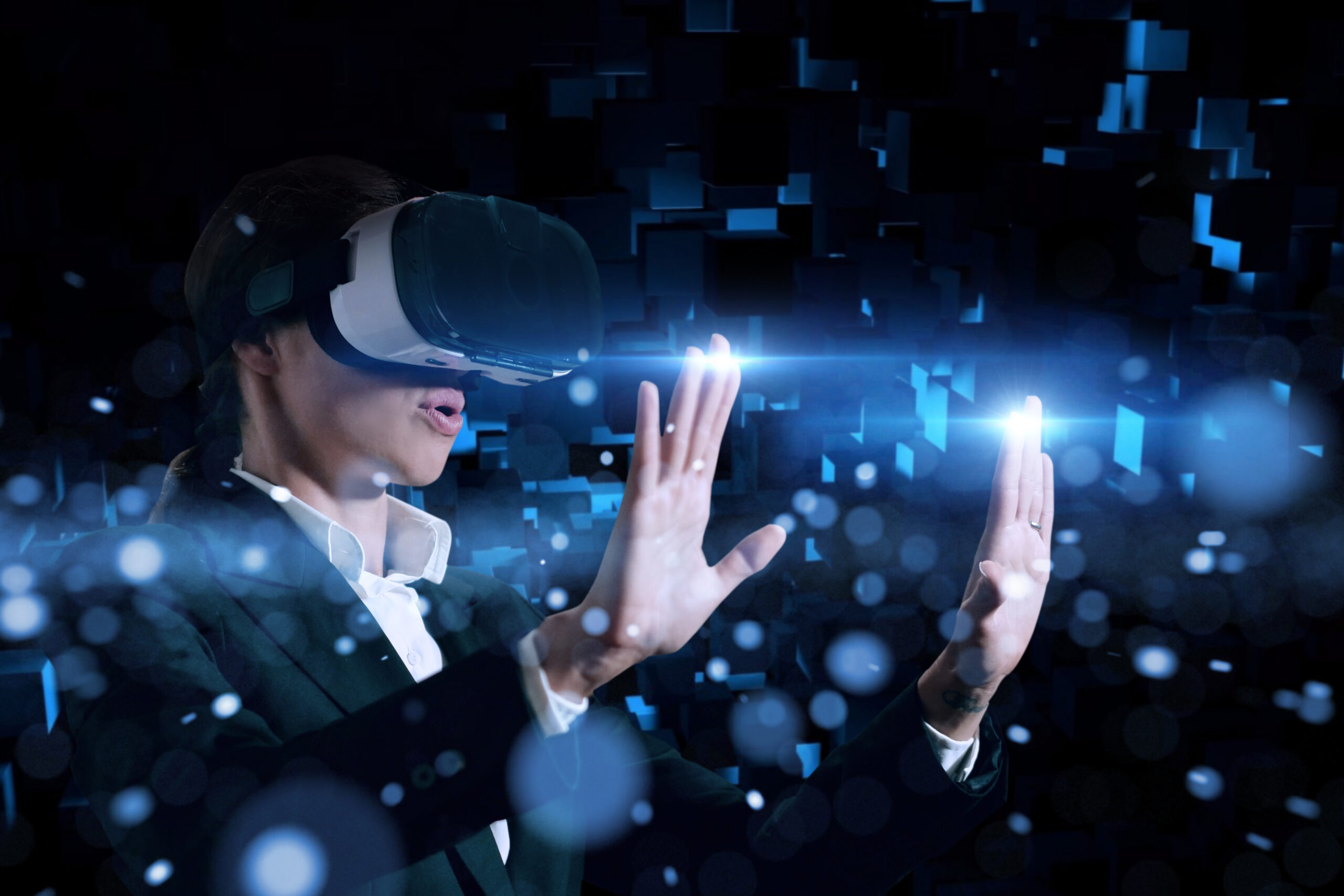 Person wearing a virtual reality headset and interacting with a glowing immersive digital environment.