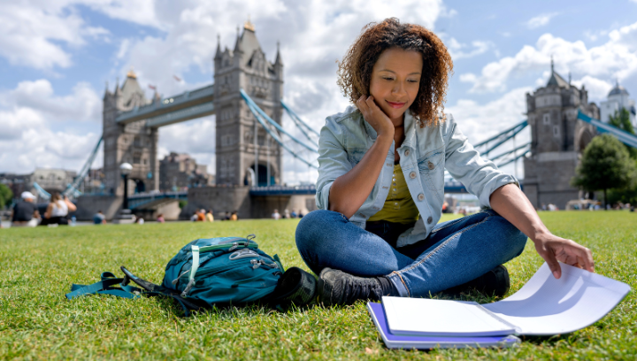 Student studying in front of bridge in London
