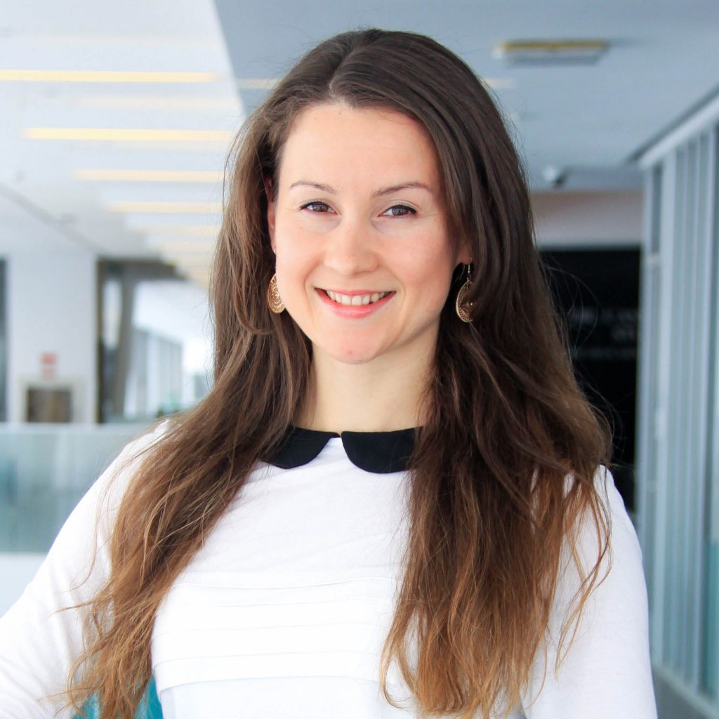 A smiling woman standing in a school hallway
