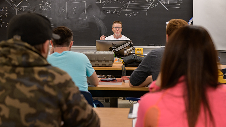 Georgian-Muskoka-carpentry-instructor-teaching-in-the-classroom-students-facing-forward-in-chairs