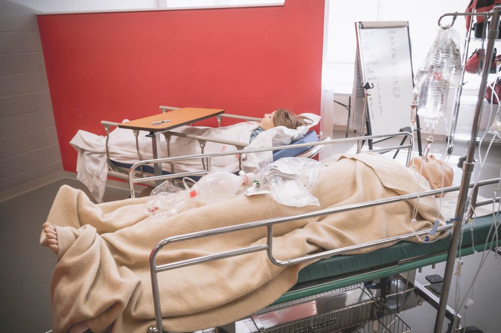 Two patient simulators hooked up to intravenous, laying on gurneys in Georgian College's paramedic lab