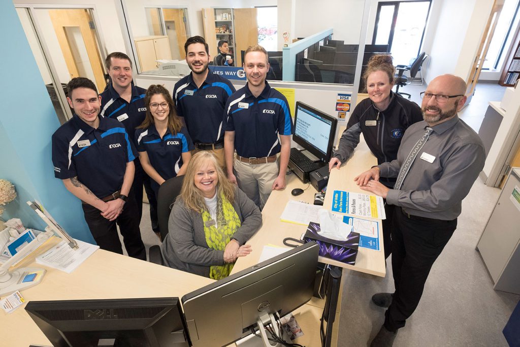 A group of people staying around a desk.