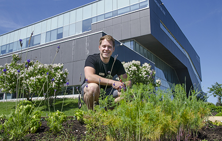 Young man bent down in a garden at Georgian's Barrie Campus