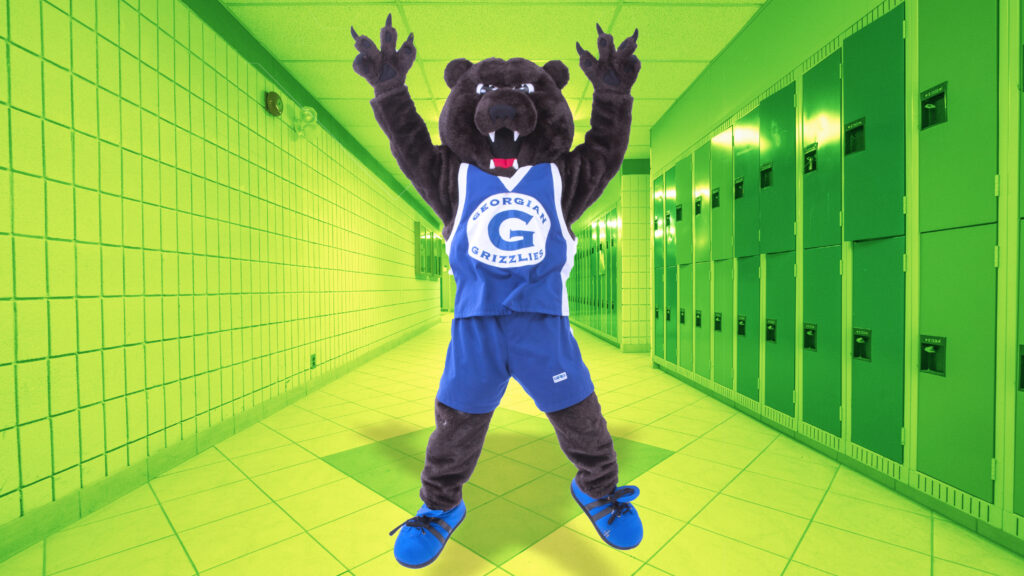 Georgian mascot, the Growler, jumps up in the air in the Barrie Campus hallway