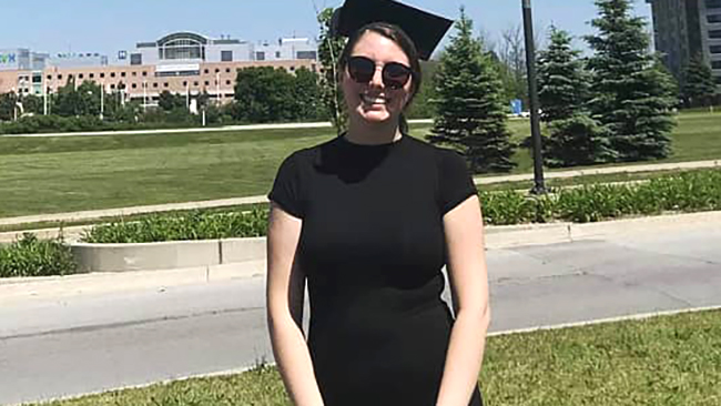 Georgian grad Haleigh Payne stands in front of the Georgian Barrie Campus at spring graduation