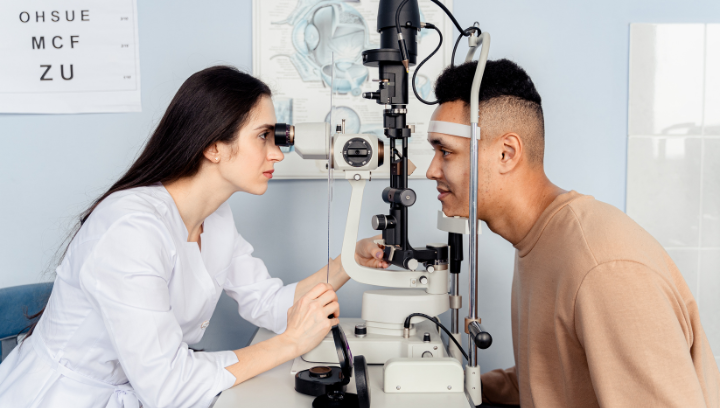 An optometrist performing an eye test on a patient.