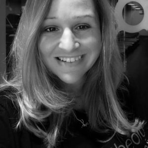 Rachel Leroux smiles at camera in black and white photo 