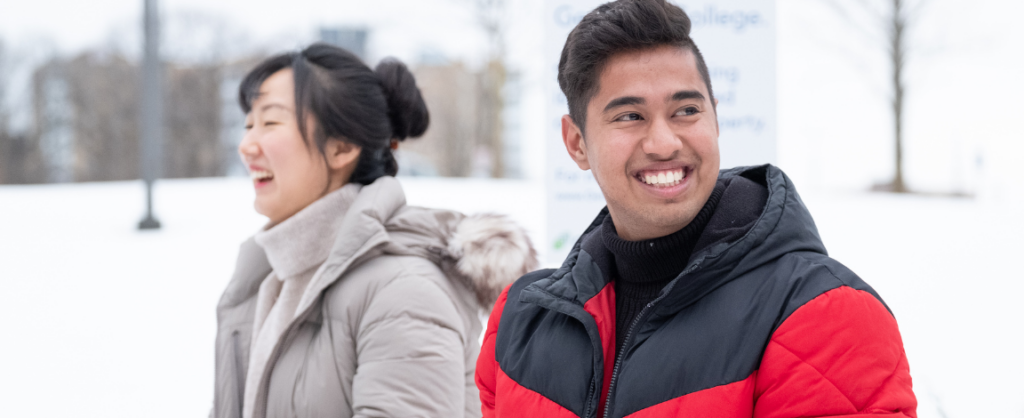 Two students outside enjoying the winter weather