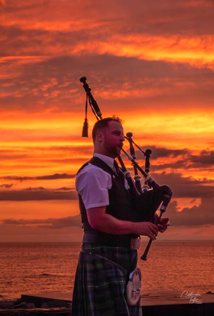 Michael Smith, the Sunset Piper, plays in front of a Friday sunset.