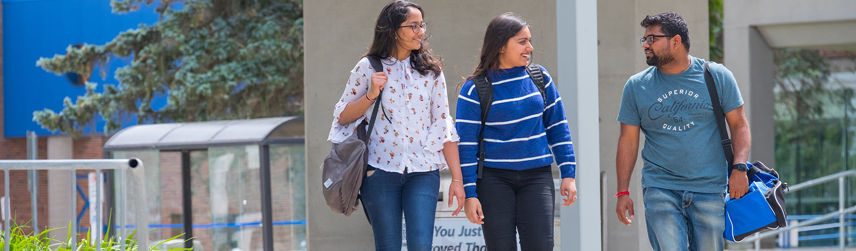 Three students walking on campus