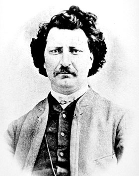 Black and white photo of Louis Riel circa 1873, courtesy Provincial Archives of Manitoba, man in formal wear, with moustache and curly hair