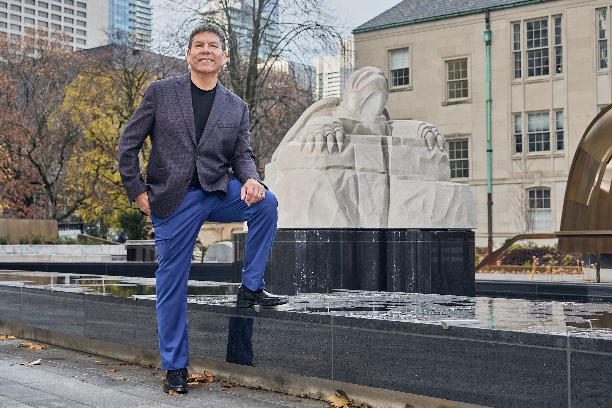 Indigenous artist and Cabinetmaking Techniques alumnus Solomon King stands outside in front of his turtle sculpture at Nathan Phillips Square in Toronto, Ontario. Canada.