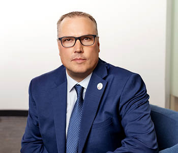Kevin Weaver sitting looking at camera with glasses