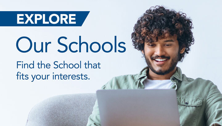 Curly haired man smiles at his laptop. "Explore Our Schools. Find the School that fits your interest."
