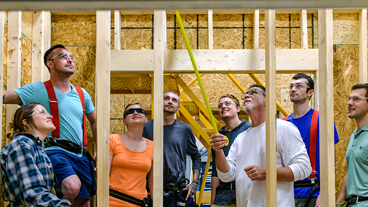 Male-and-female-construction-trades-pre-apprenticeship-students-flank-carpentry-instructor-Van-Rochon-in-the-shop
