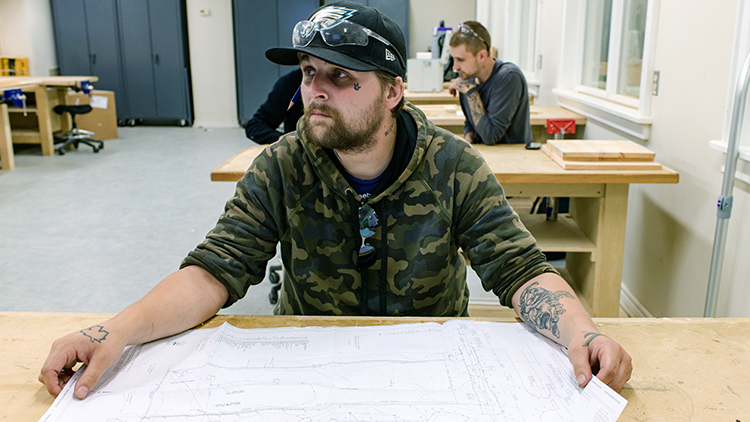 Male-construction-trades-pre-apprenticeship-student-looks-at-schematic-while-in-class-at-Georgian-Muskoka