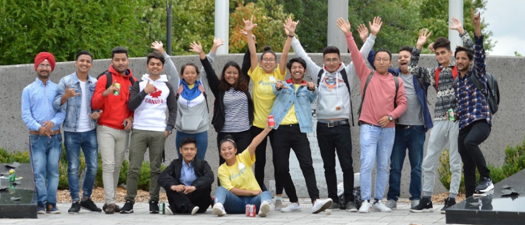 15 students standing infront of the cenotaph on orientation day