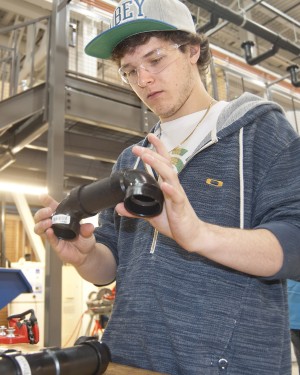 Connor Finley inspects a plumbing joint that he was working on at the Midland Campus
