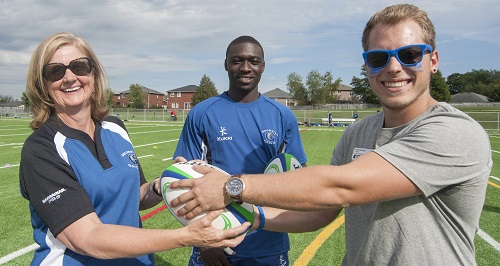 Georgian College President and CEO MaryLynn West-Moynes, Georgian rugby player Kirk Sarfo, and President of the Barrie Campus Georgian College Students' Association Avery Konda, celebrate at the grand opening of the Georgian College Sports Field.