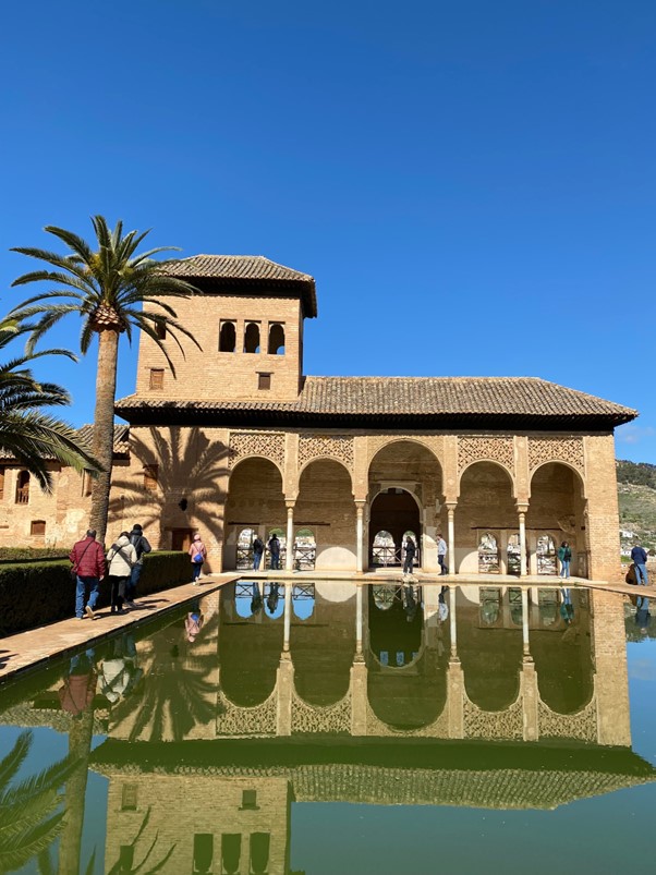 A brown building with a small pond and palm tree in front of it in Almeria, Spain.