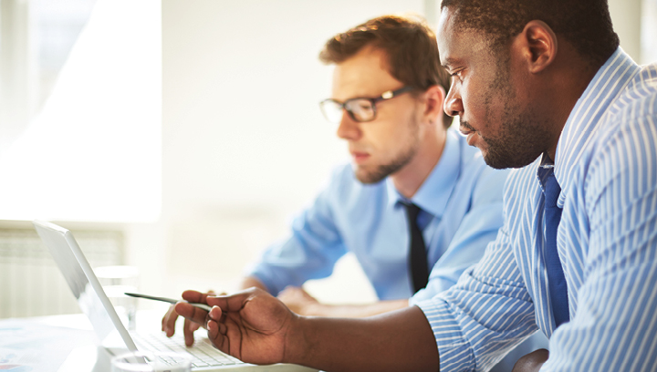 two men looking at computer screen