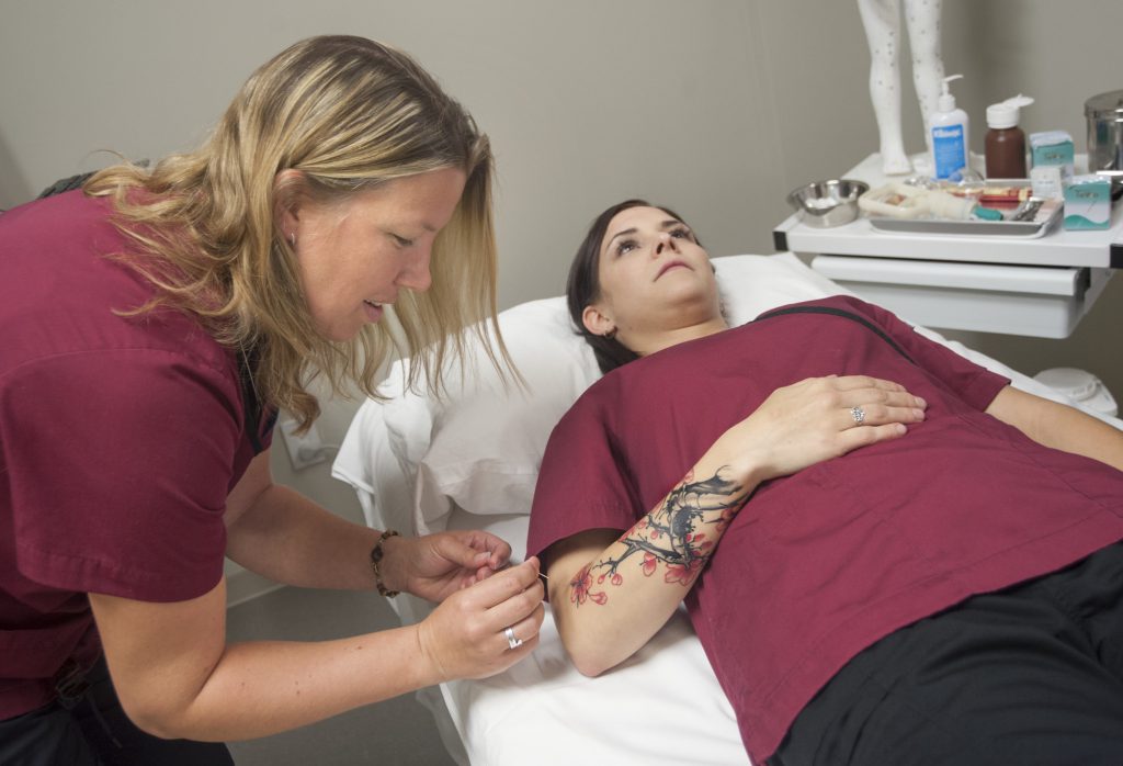 students performing acupuncture on each other