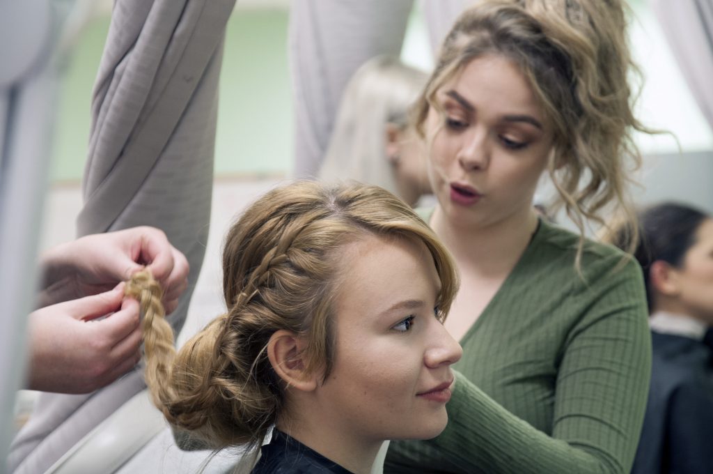Student hairstylist braiding hair