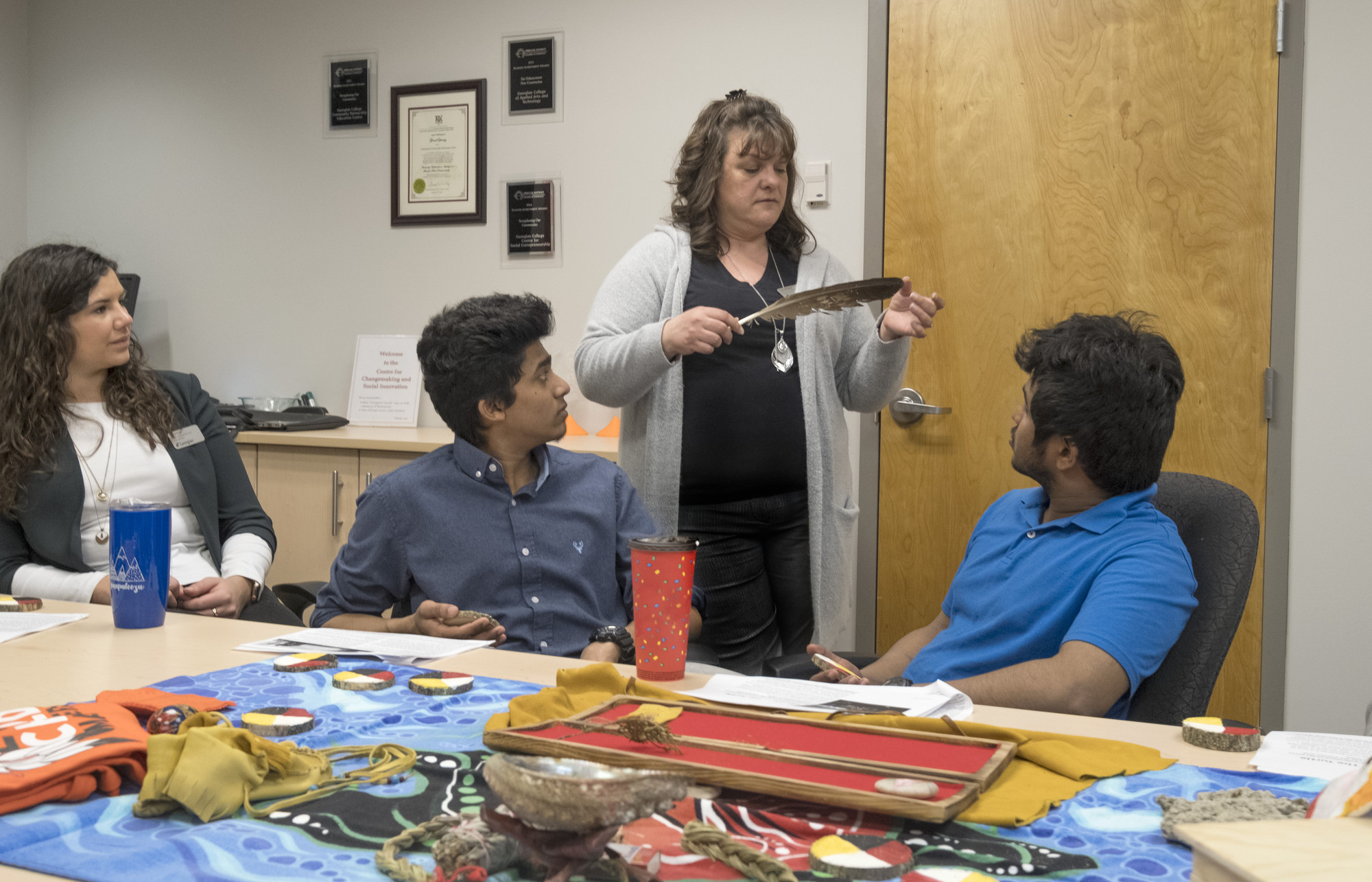 3 students and a teacher in the Indigenous Enterprises CIP lab