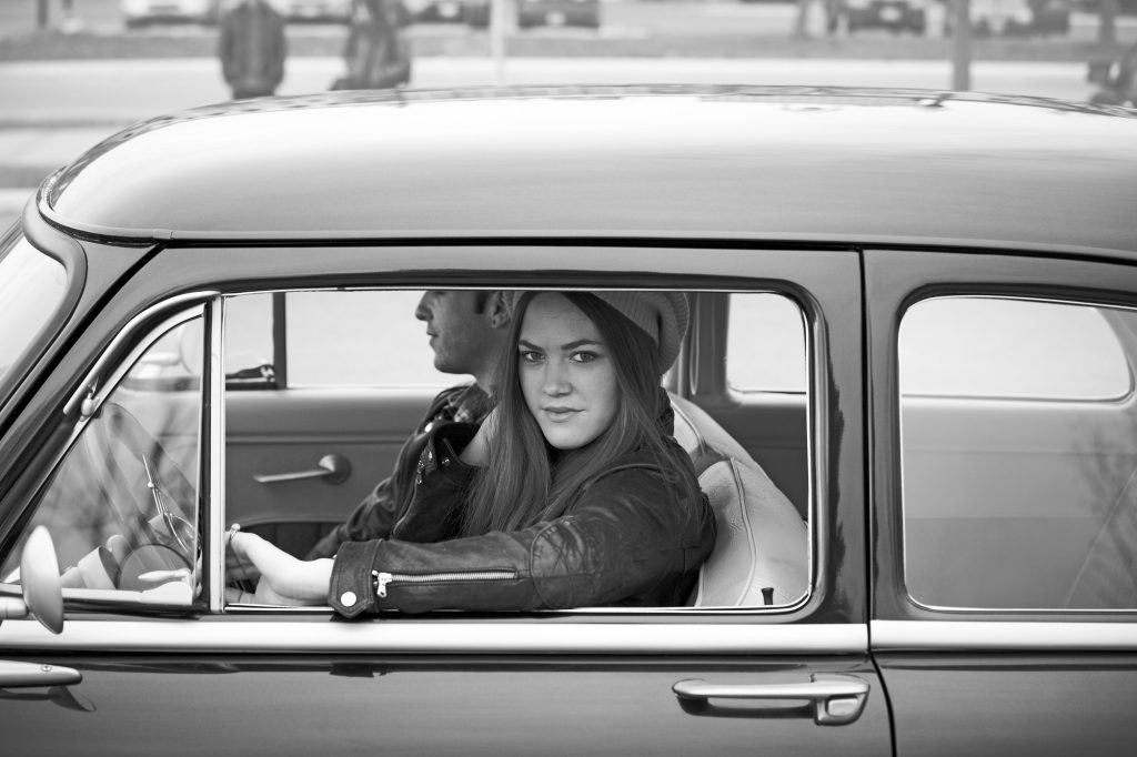 2 students sitting in an old car