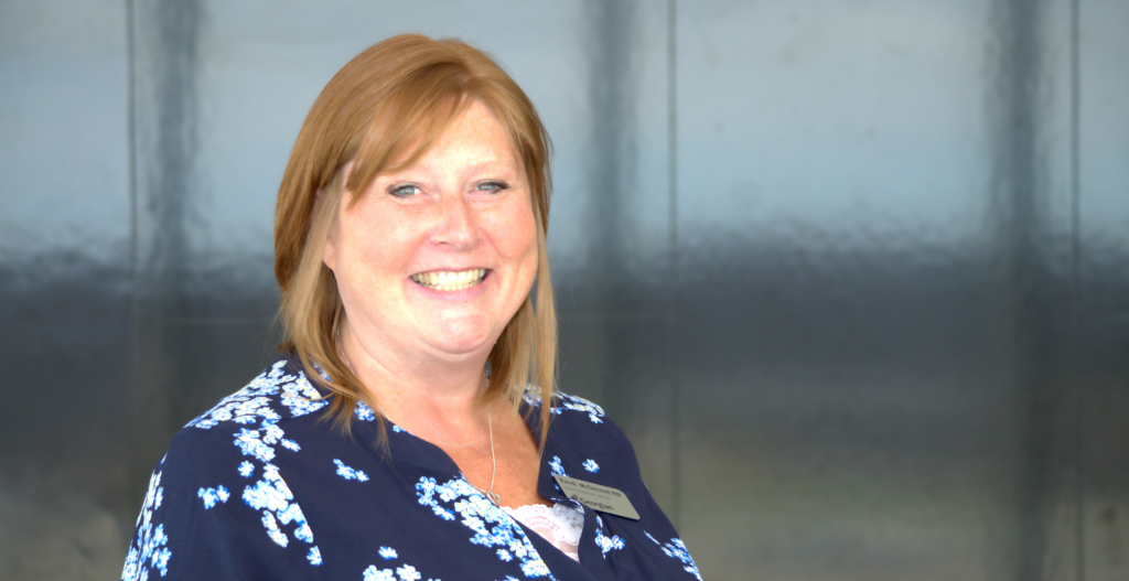 Person, pictured from chest up, smiles at the camera.